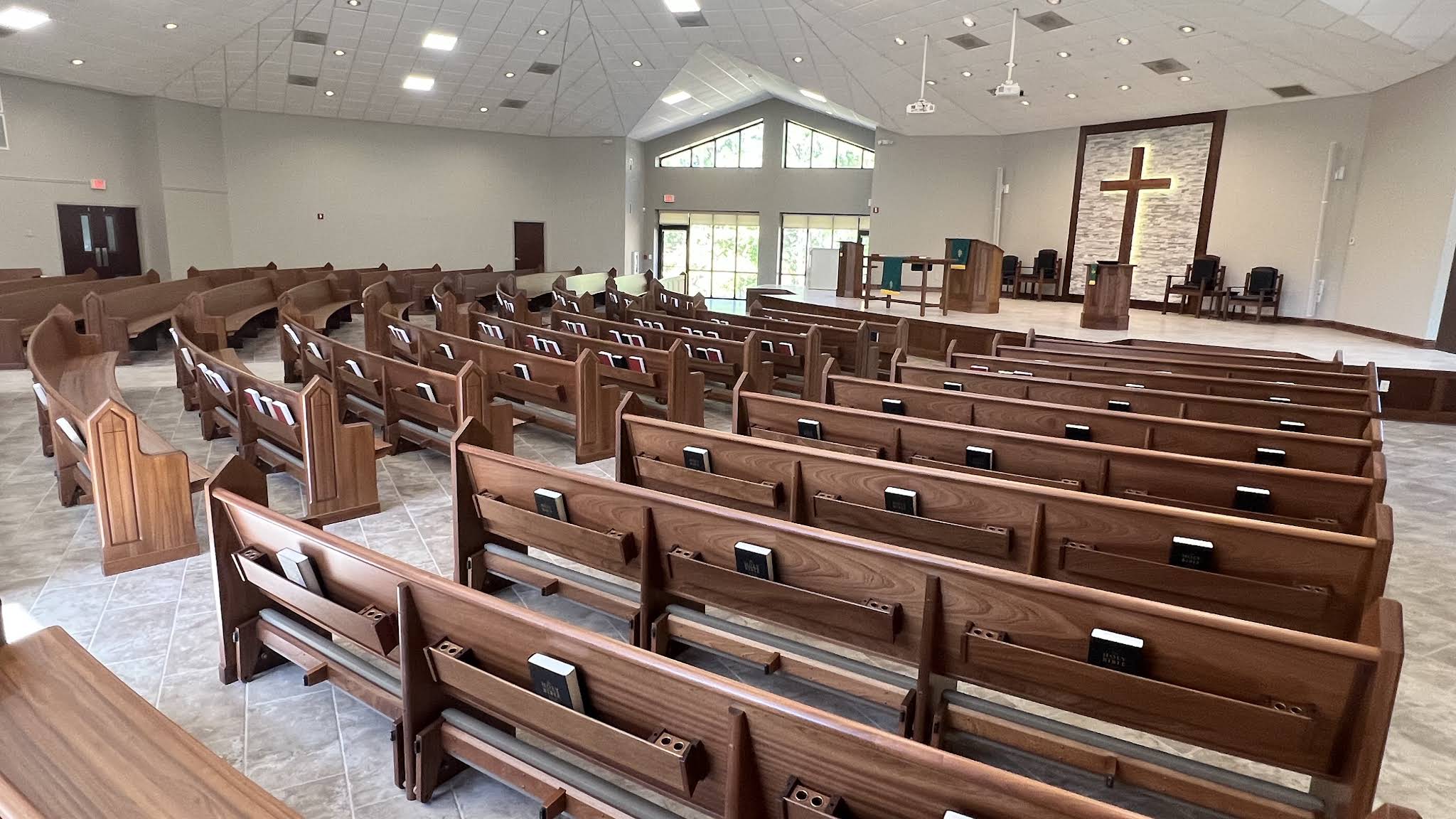 The sanctuary from the pews, looking toward the pulpit and the wooden cross.